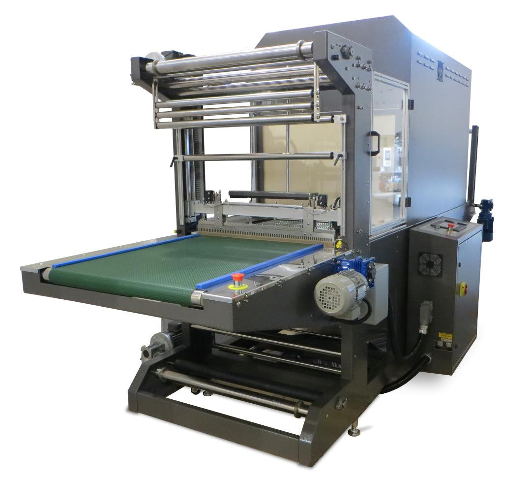 A large industrial shrink bundler with a green conveyor belt, metal rollers, and a gray control cabinet, photographed on a plain white background.