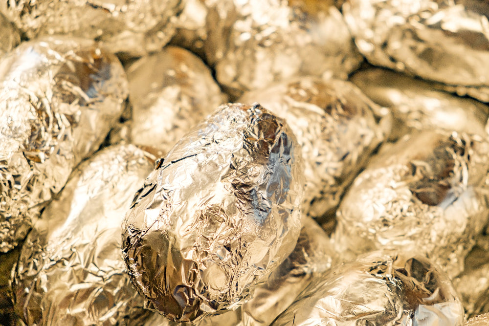 Foil wrapped potatoes in bulk.
